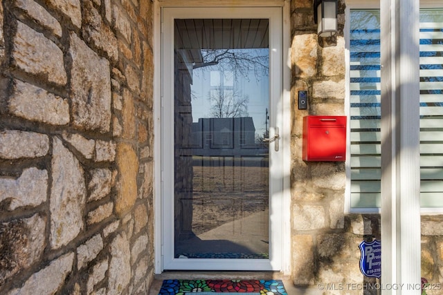 property entrance with stone siding