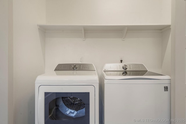 clothes washing area with washing machine and dryer