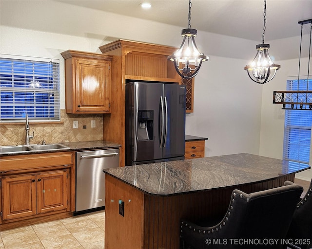 kitchen with tasteful backsplash, brown cabinetry, a breakfast bar, stainless steel appliances, and a sink