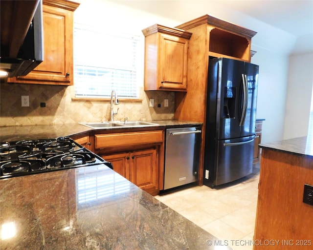 kitchen with black appliances, decorative backsplash, brown cabinets, and a sink