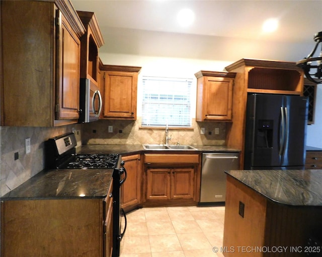 kitchen with light tile patterned floors, stainless steel appliances, a sink, backsplash, and brown cabinets