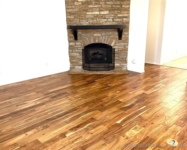 room details with a stone fireplace and wood finished floors