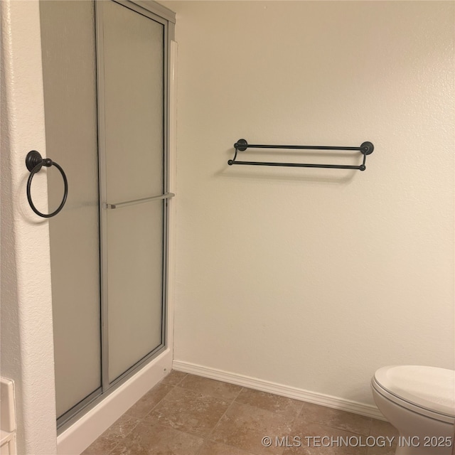 bathroom featuring an enclosed shower, toilet, and baseboards