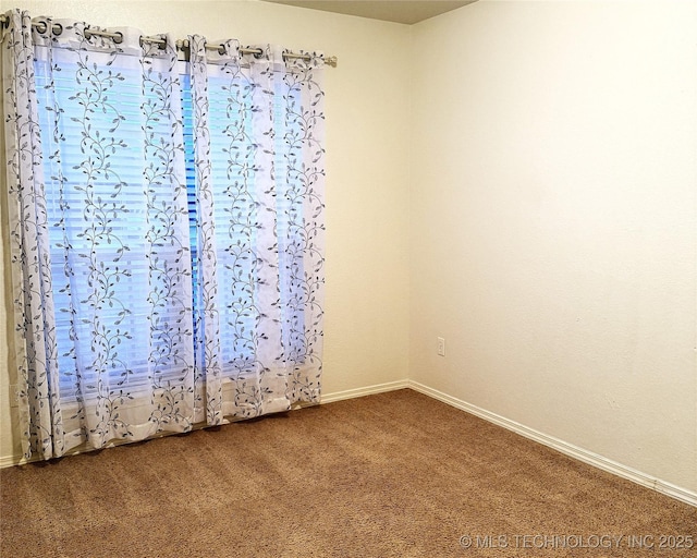 empty room with dark carpet and baseboards