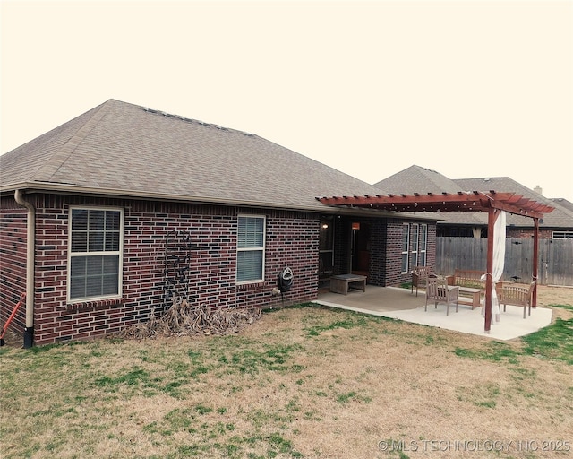 rear view of property with brick siding, a patio area, fence, and a pergola