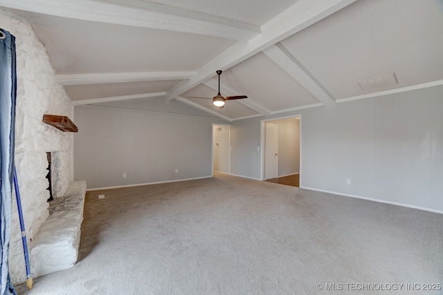 unfurnished living room featuring vaulted ceiling with beams, a stone fireplace, a ceiling fan, baseboards, and carpet