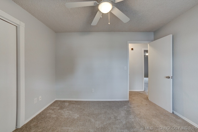 carpeted spare room with a textured ceiling, ceiling fan, and baseboards