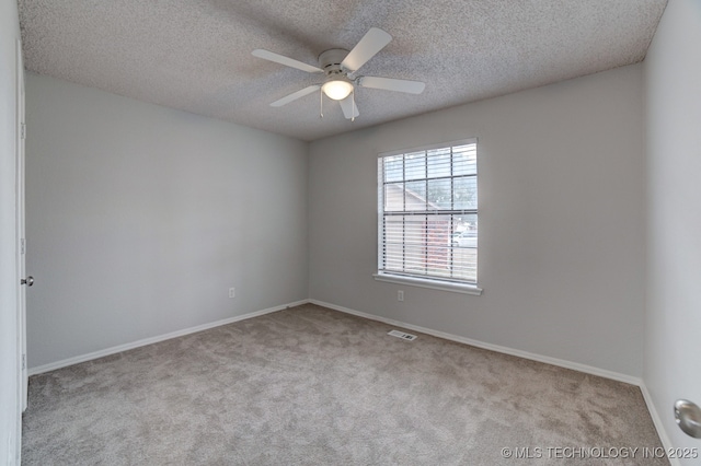 unfurnished room with ceiling fan, a textured ceiling, carpet, and visible vents