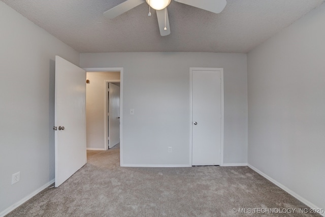 unfurnished bedroom featuring carpet flooring, a textured ceiling, and baseboards