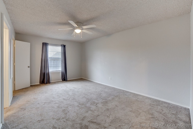 carpeted empty room featuring a textured ceiling, a ceiling fan, and baseboards