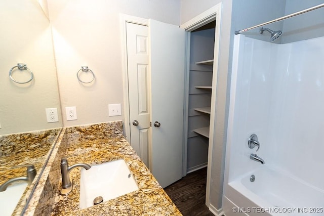 bathroom with shower / bathing tub combination, wood finished floors, and vanity