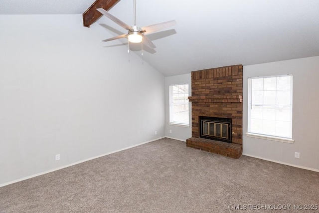 unfurnished living room with lofted ceiling with beams, a fireplace, a ceiling fan, baseboards, and carpet