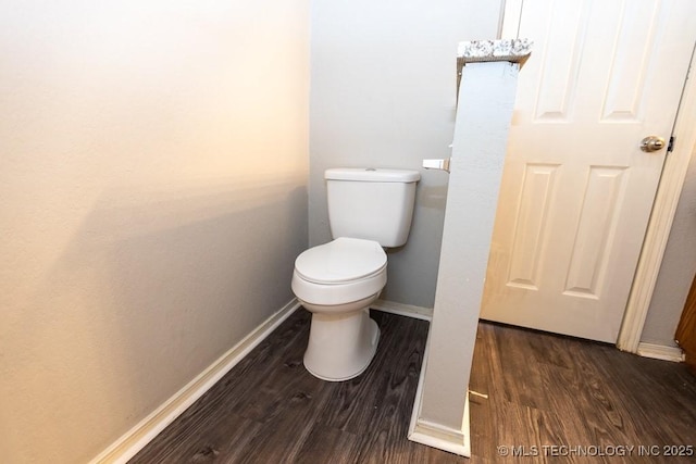 bathroom with wood finished floors, toilet, and baseboards