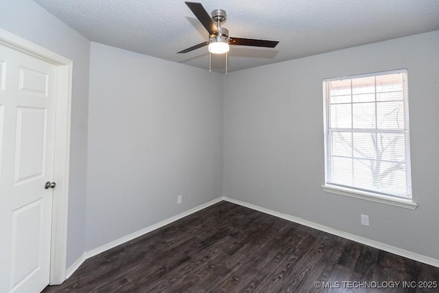 spare room with dark wood finished floors, a textured ceiling, and baseboards