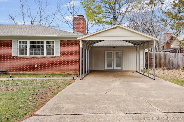 view of front of house with french doors, a chimney, fence, and brick siding