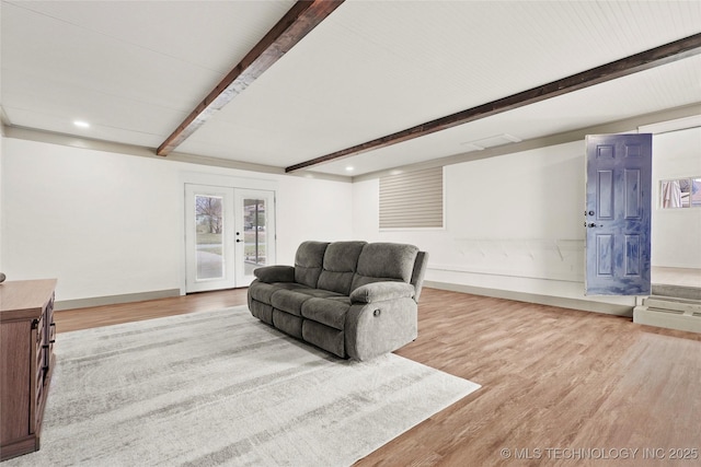 living area featuring french doors, beamed ceiling, baseboards, and wood finished floors