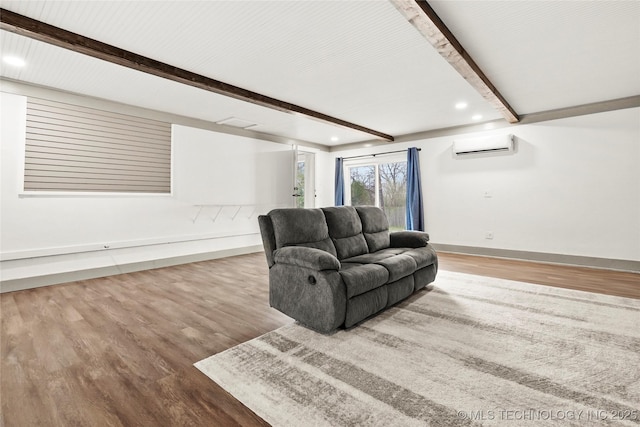 living area featuring beam ceiling, recessed lighting, a wall mounted AC, wood finished floors, and baseboards