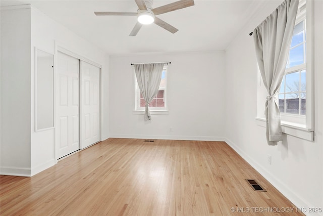 unfurnished bedroom featuring light wood-style floors, a closet, visible vents, and baseboards