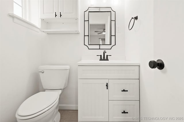 bathroom with vanity, toilet, and baseboards