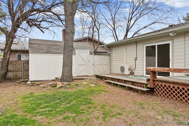 view of yard featuring fence, a deck, an outdoor structure, and a storage unit