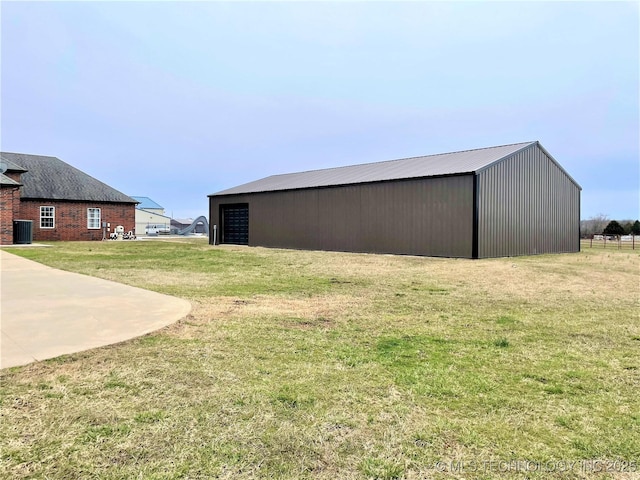 view of yard featuring an outdoor structure, central AC, and an outbuilding