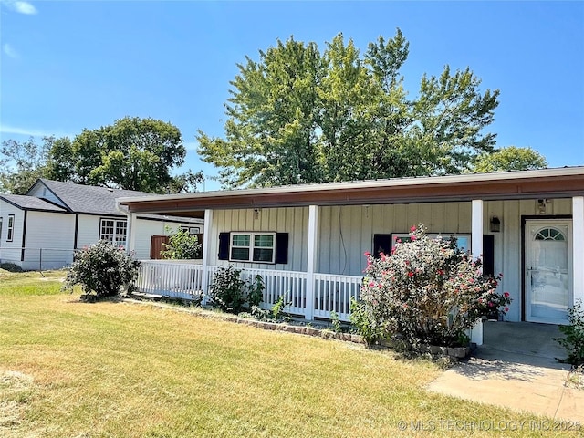 view of front of property with a porch, board and batten siding, and a front lawn