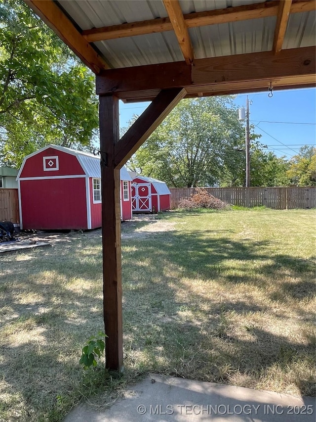 view of yard featuring an outdoor structure, fence, and a storage unit