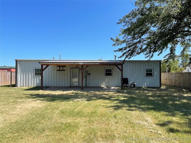 back of property with a yard and fence