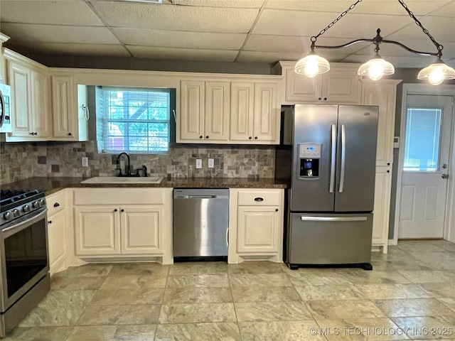 kitchen featuring stainless steel appliances, dark countertops, a sink, and decorative backsplash