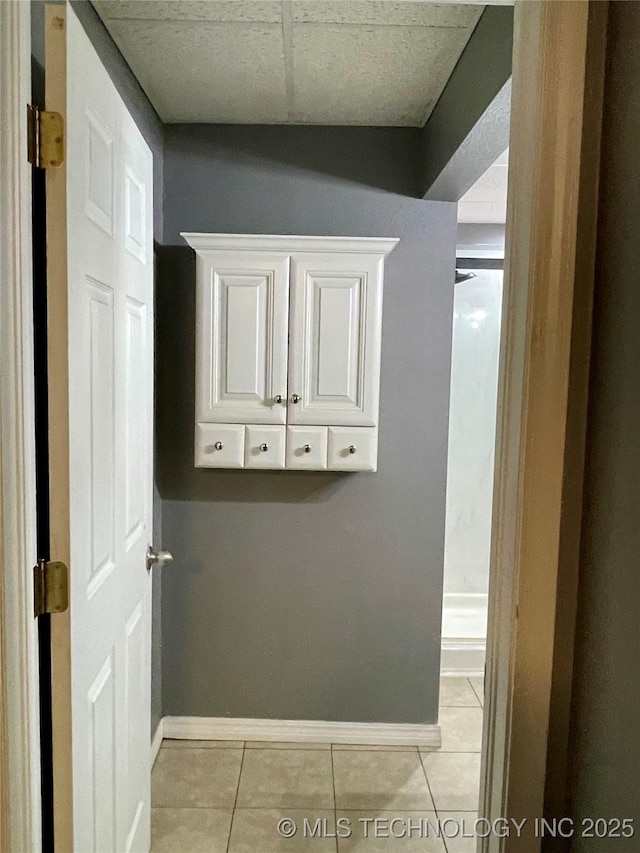 laundry area with light tile patterned flooring and baseboards