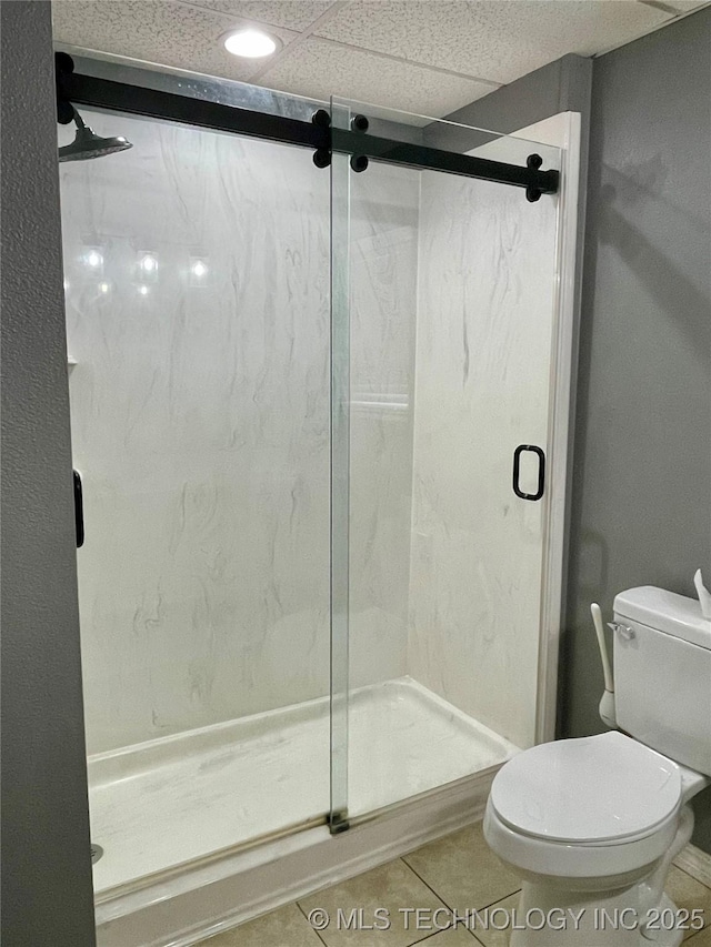 full bath with a stall shower, toilet, and tile patterned floors