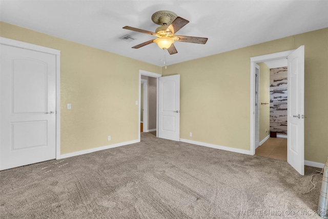 unfurnished bedroom with carpet floors, visible vents, baseboards, and a ceiling fan