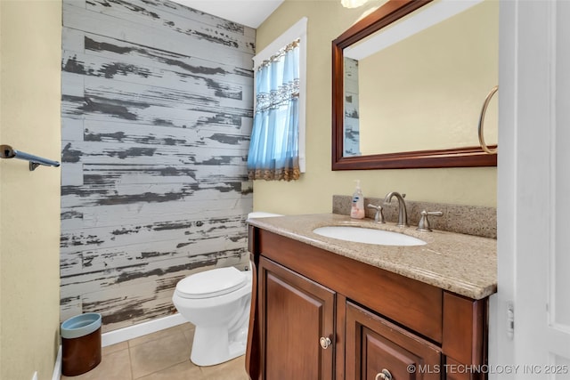 bathroom with wooden walls, tile patterned flooring, vanity, and toilet