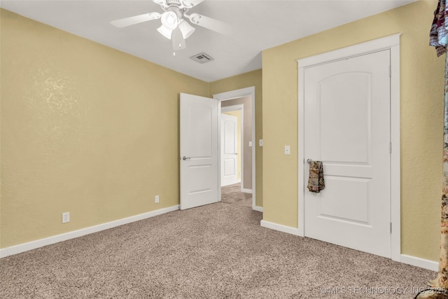 unfurnished bedroom with baseboards, visible vents, ceiling fan, and carpet flooring