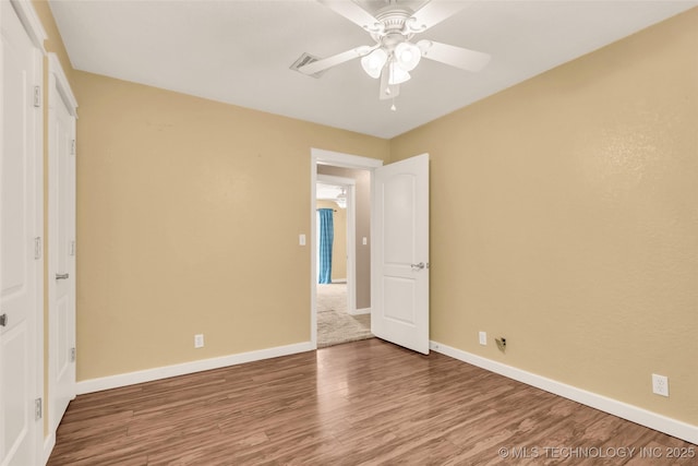 unfurnished bedroom with visible vents, wood finished floors, a ceiling fan, and baseboards