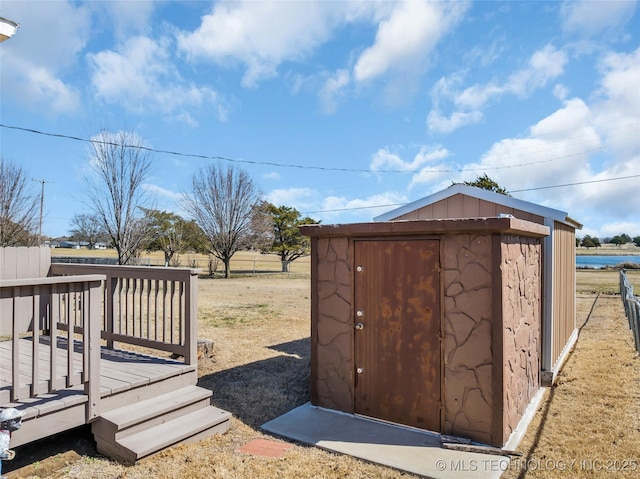 exterior space featuring a deck, a shed, and an outdoor structure