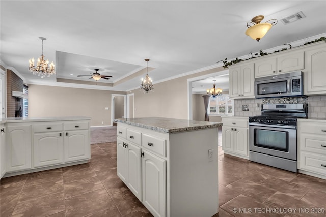 kitchen with decorative light fixtures, stainless steel appliances, visible vents, backsplash, and ornamental molding