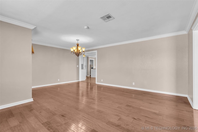 unfurnished room featuring wood finished floors, visible vents, baseboards, an inviting chandelier, and crown molding