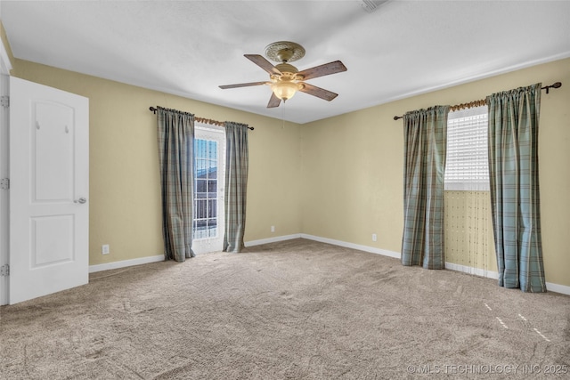 empty room with carpet floors, baseboards, and a ceiling fan