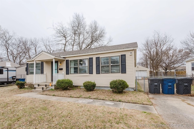 bungalow-style home featuring crawl space, roof with shingles, fence, and an outbuilding