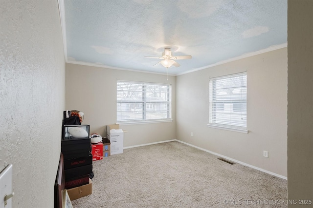 interior space with visible vents, crown molding, a textured ceiling, and baseboards