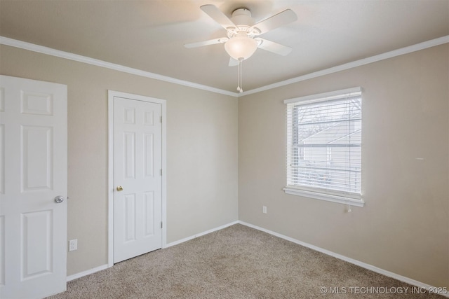 unfurnished bedroom featuring ornamental molding, carpet, ceiling fan, and baseboards