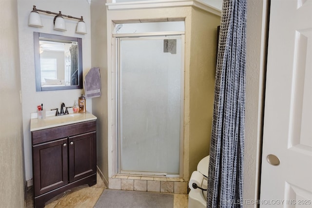 full bath featuring toilet, a stall shower, and vanity