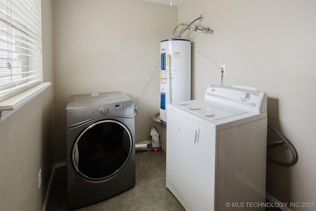 laundry area featuring laundry area, washing machine and clothes dryer, electric water heater, and tile patterned floors