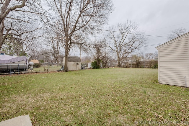 view of yard with a storage shed, a fenced backyard, and an outdoor structure