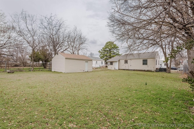 view of yard featuring an outbuilding, a shed, and fence