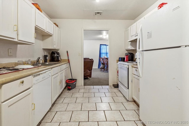 kitchen featuring white appliances, white cabinetry, a sink, and under cabinet range hood