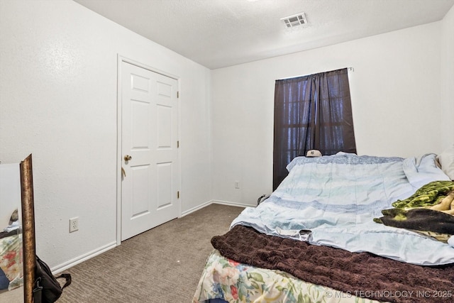 carpeted bedroom featuring baseboards, visible vents, and a textured ceiling