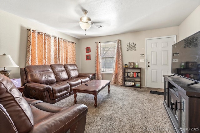 carpeted living area featuring visible vents, ceiling fan, and a textured ceiling