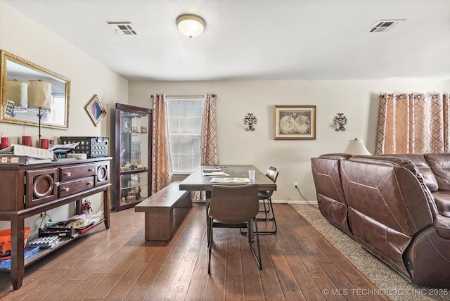 office space with dark wood-style flooring, visible vents, and baseboards